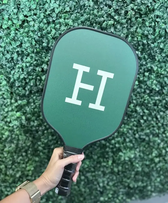 Custom green pickleball paddle with a large white monogram
