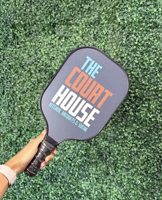 Custom charcoal pickleball paddle printed with The Court House venue logo