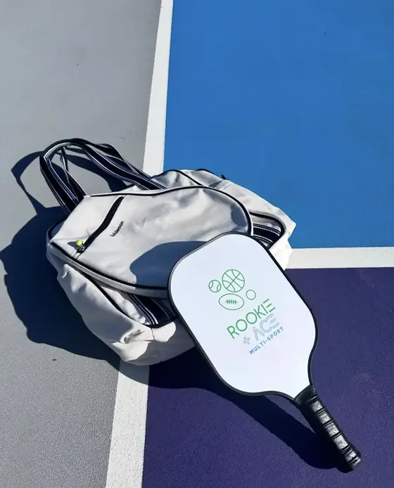 Custom white pickleball paddle with a multi-sport club logo