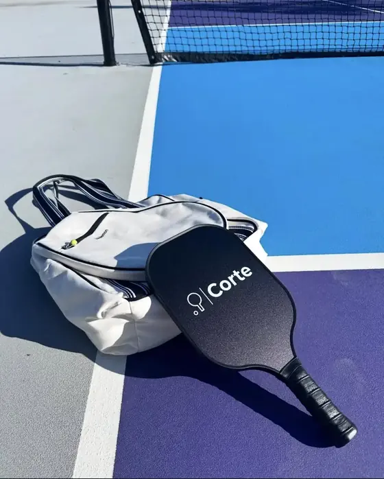 Custom black pickleball paddle with a minimal brand logo
