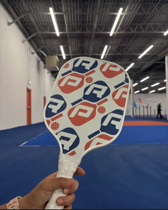Custom navy and red pickleball paddle with an all-over letter pattern